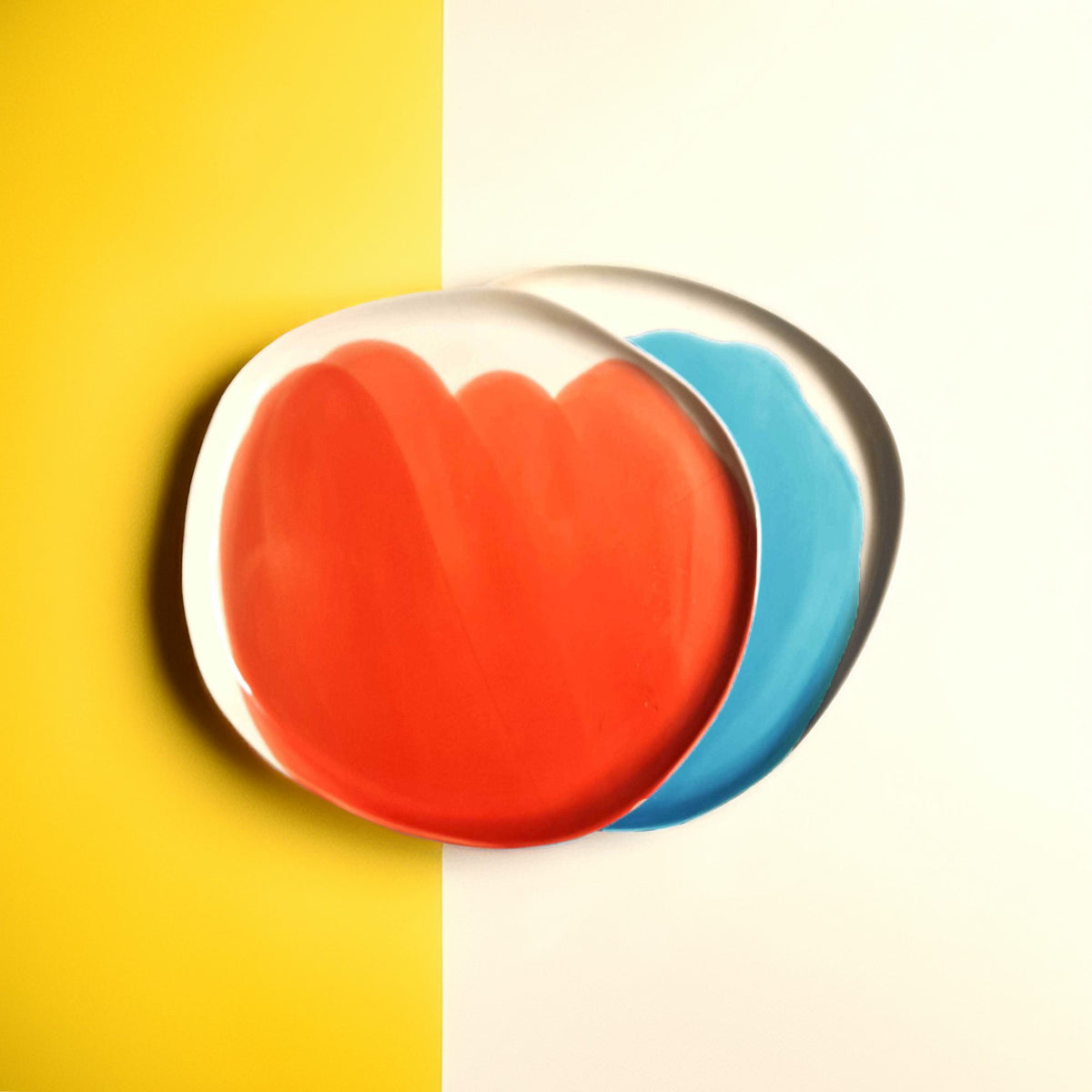 Red and turquoise handmade side plates on a yellow and white background
