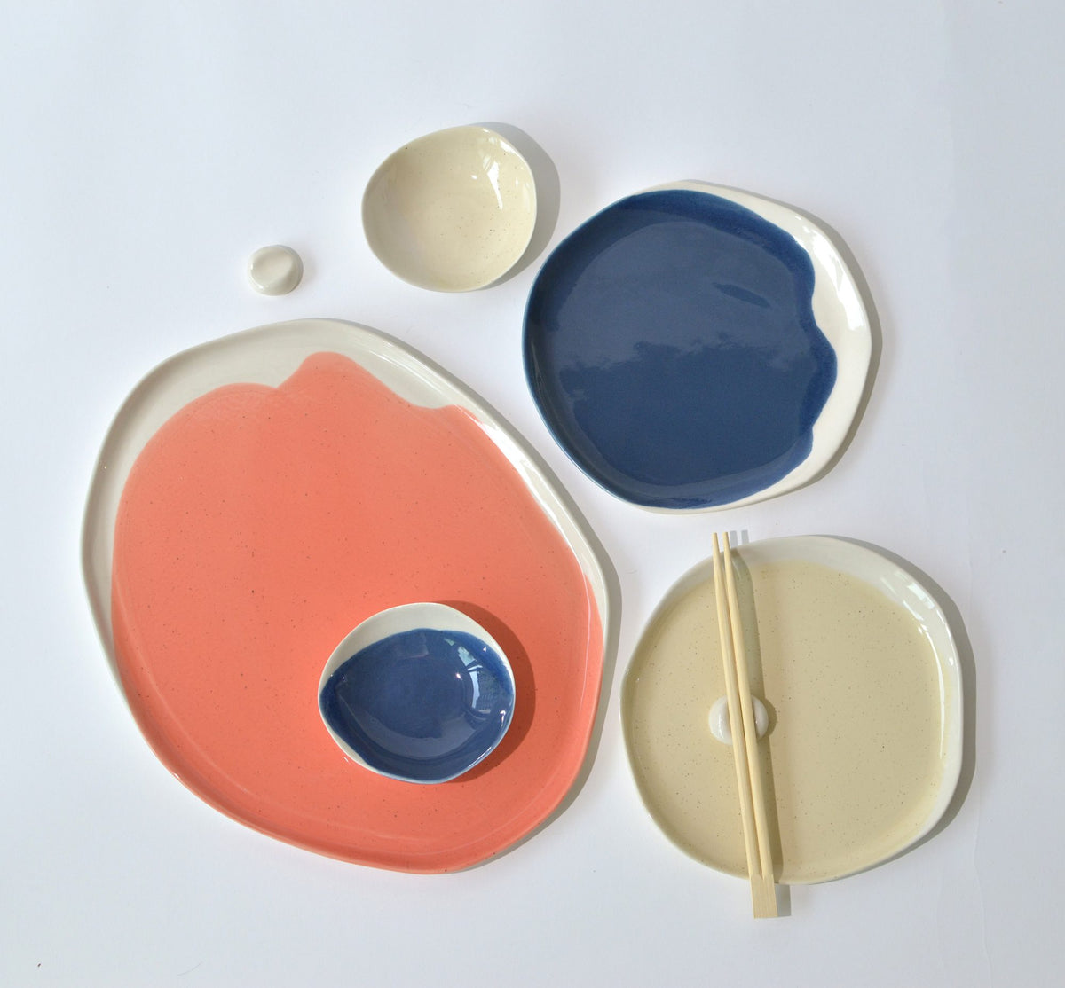 Sushi set pieces in coral, denim blue and cream: tray, plates, dip bowls and a chopstick rest