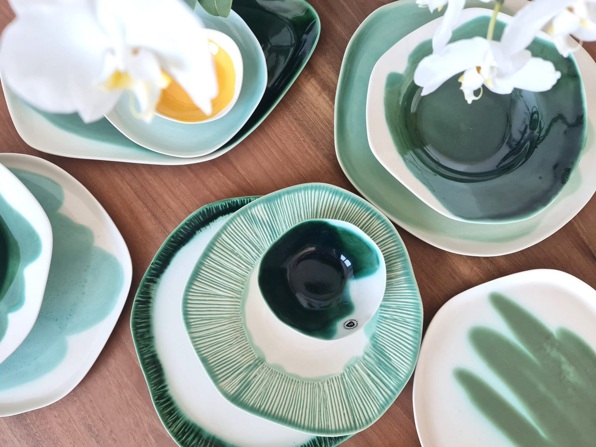 Textured and Color collection ceramic plates and bowls in green and mint glazes with white orchids