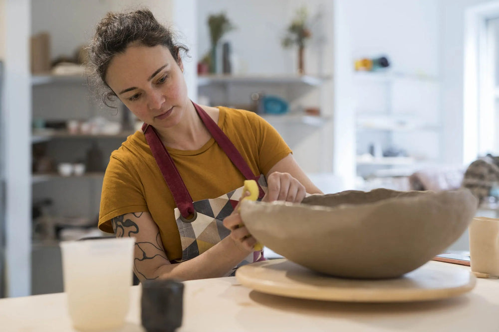 Maria Baleva shaping a large clay bowl on a wheel at the Pottery & Poetry studio in Sofia