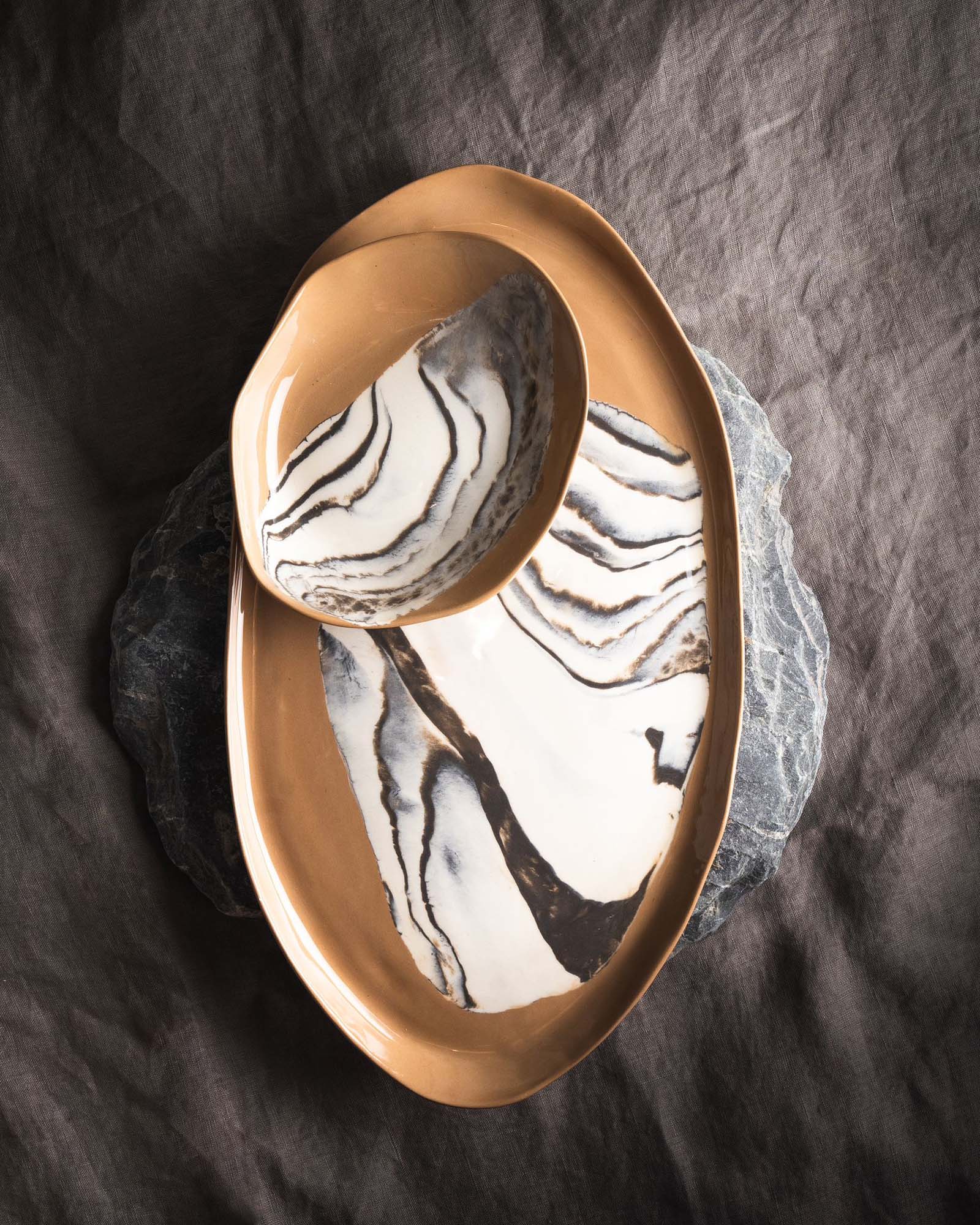 Sculptural bowl in black porcelain with layered blue floating glazes and textured exterior
